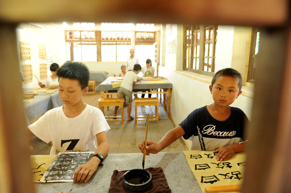 8月17日，孩子們在國學班課堂上練習書法。